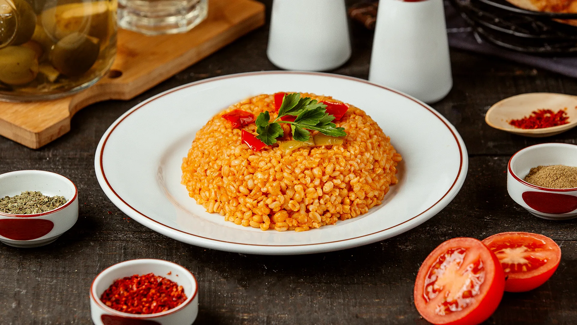 Bulgur Pilavı Kaç Kalori – Bir porsiyon bulgur pilavı, yoğurt ve sebze garnitürleriyle birlikte tabakta sunulmuş.